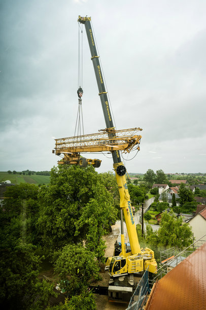 Liebherr's Mobile crane lifts construction crane over treetops